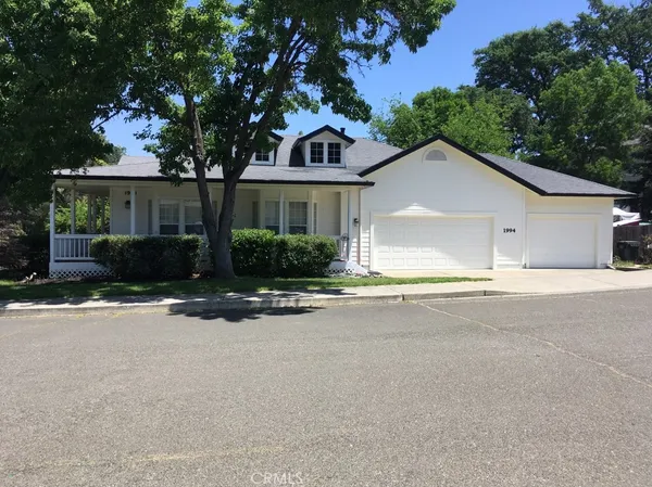 front view of house with a yard and palm trees