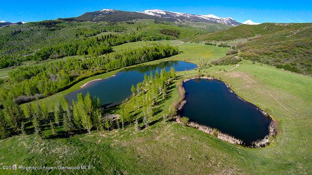 a view of a lush green hillside and a building in the background