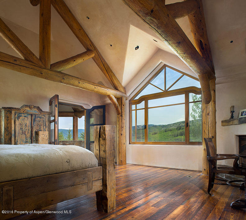 1500 Owl Creek Ranch Road Aspen, CO 81611 - Photo 7 of 18 a bedroom with a bed a mirror on dresser and a large window
