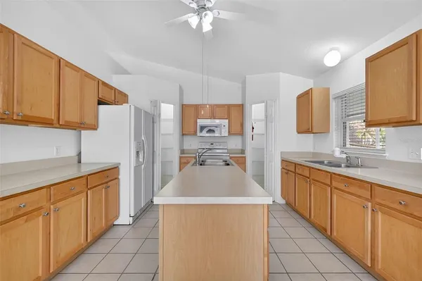 a kitchen with stainless steel appliances a sink dishwasher stove refrigerator and cabinets
