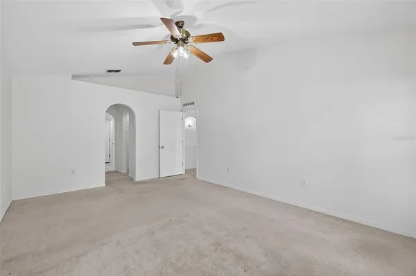 an empty room with ceiling fan and window