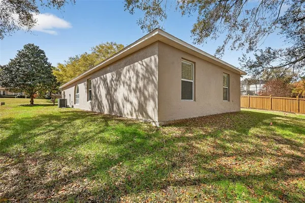a view of a house with backyard and tree