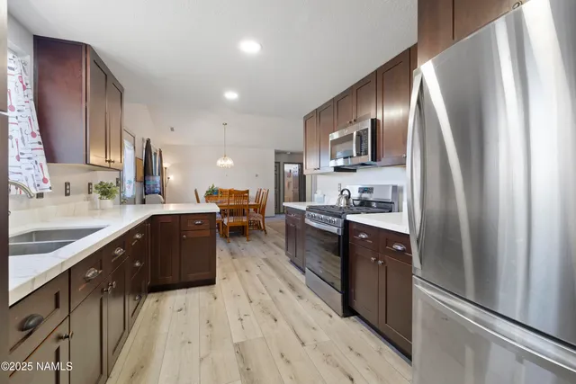 a kitchen with stainless steel appliances granite countertop refrigerator a sink dishwasher a stove top oven and refrigerator