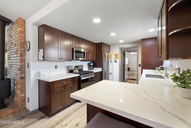 a large kitchen with kitchen island a sink stainless steel appliances and cabinets