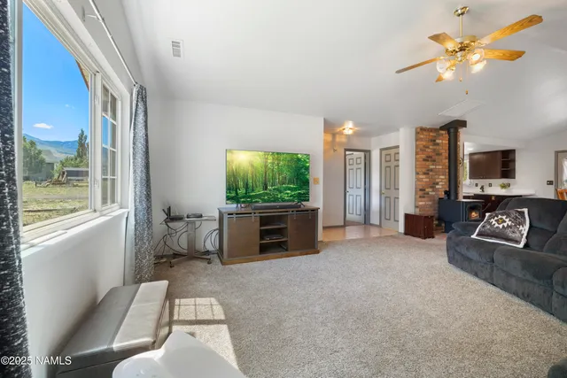 a living room with furniture a window and a flat screen tv