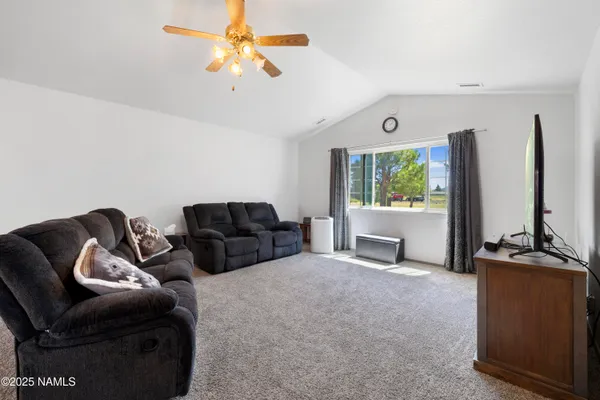 a living room with furniture a window and a flat screen tv
