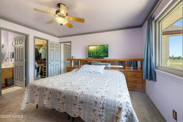 a bed sitting in a spacious bedroom next to a window