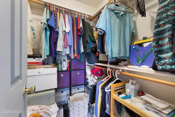 a view of walk in closet with clothes and shoes
