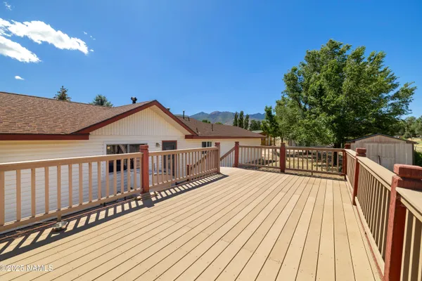 a view of a wooden deck and a backyard