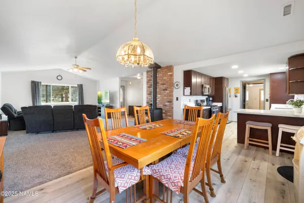 a view of a dining room with furniture a chandelier and wooden floor