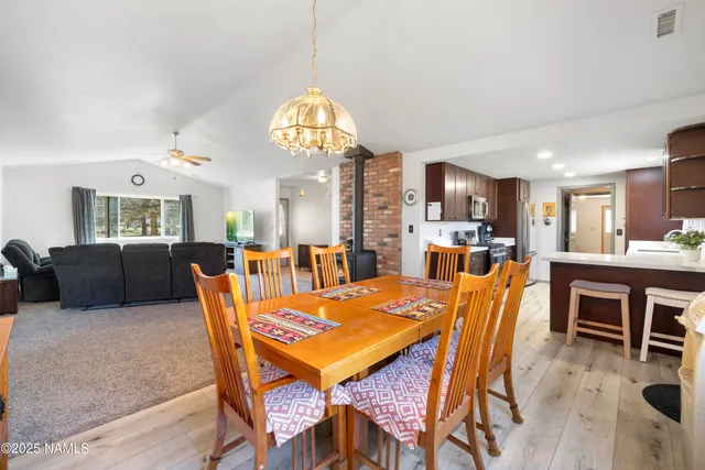 a view of a dining room with furniture a chandelier and wooden floor