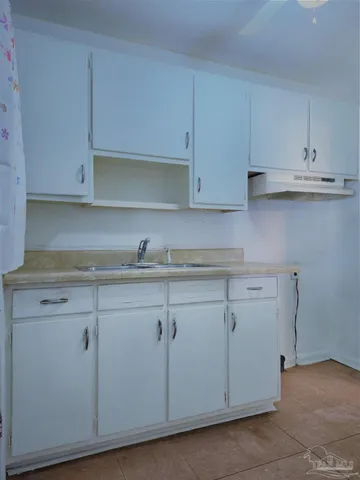 a kitchen with granite countertop white cabinets and a sink