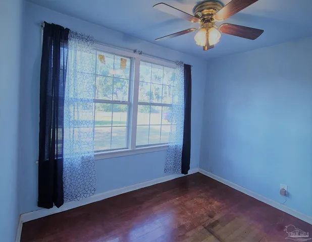 an empty room with a window and a fan