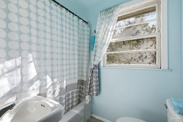a bathroom with a sink a toilet and a window