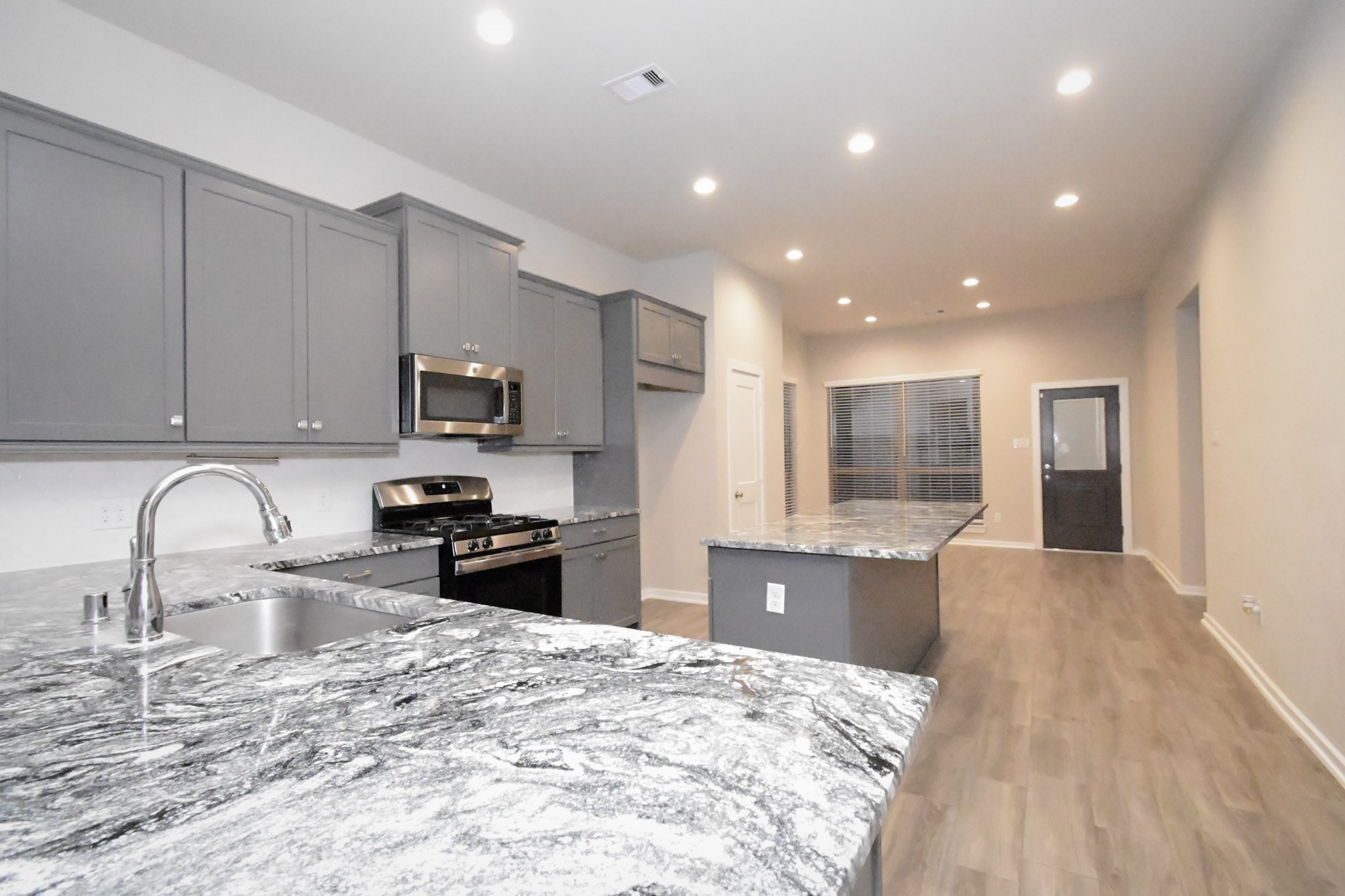 10533 Wild Chives Conroe, TX 77385 - Photo 17 of 36 a kitchen with granite countertop a stove and a sink