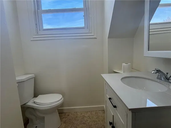 a bathroom with a toilet a sink and mirror