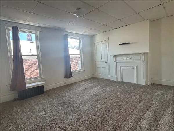 an empty room with windows and cabinet