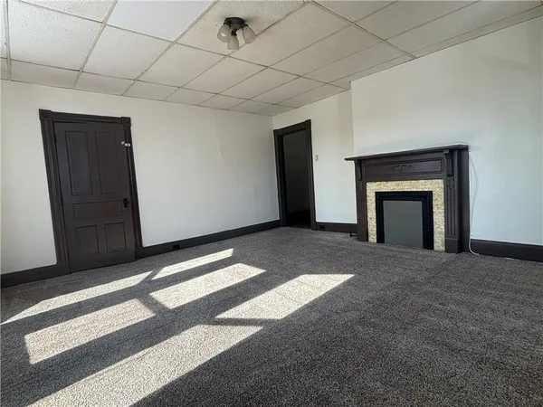 a view of an empty room with a fireplace and a window