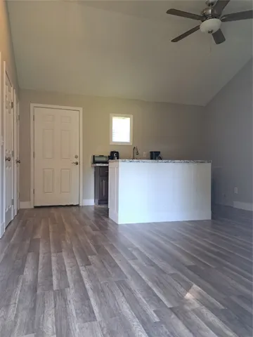 a view of a livingroom with wooden floor and a ceiling fan