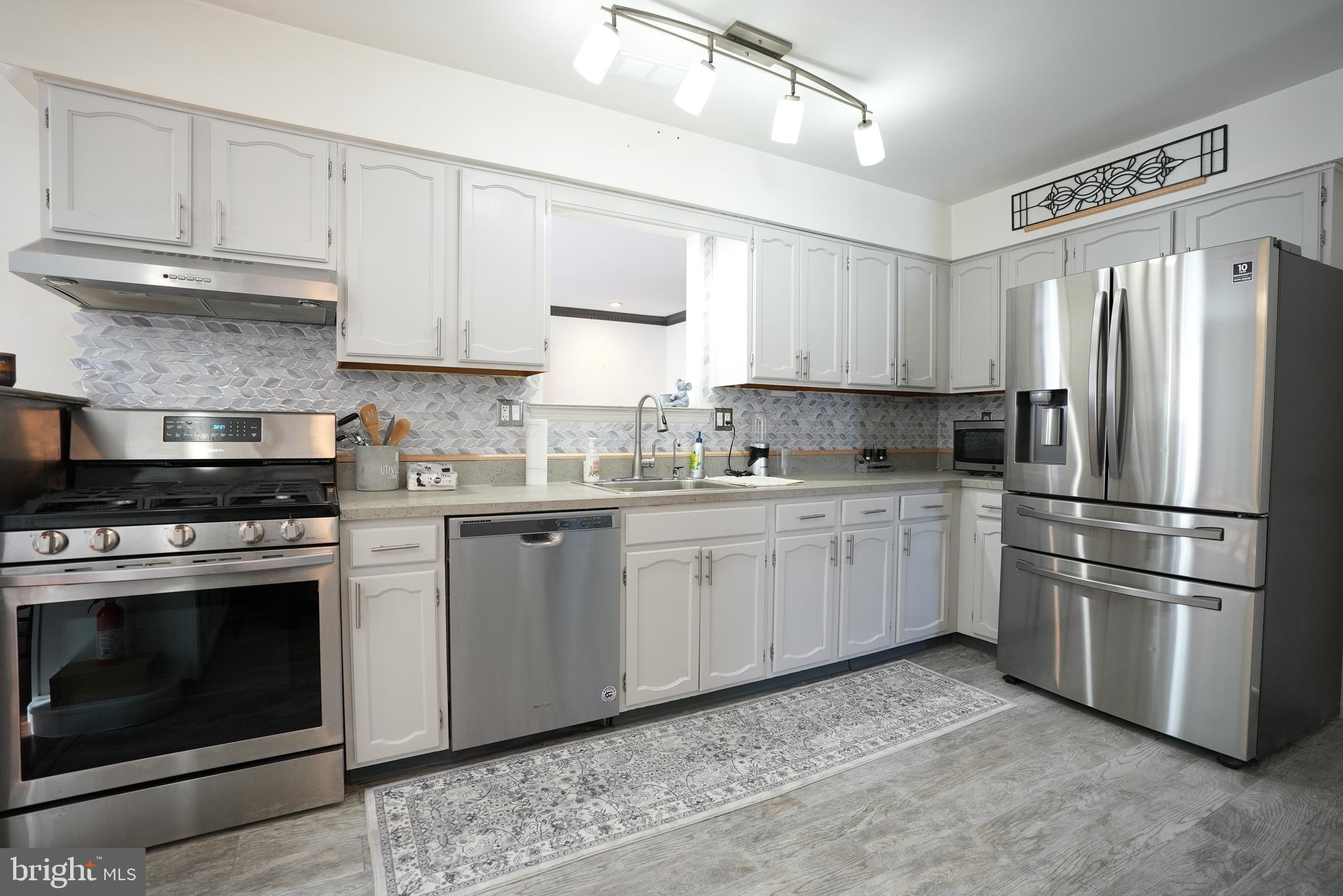 18 Cobblestone Court Sicklerville, NJ 08081 - Photo 11 of 56 a kitchen with stainless steel appliances granite countertop a refrigerator sink stove and white cabinets