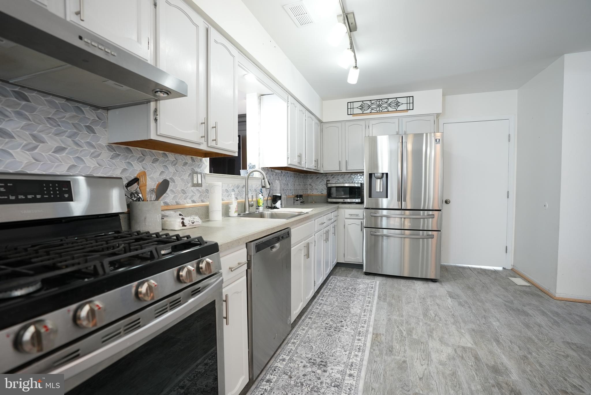 18 Cobblestone Court Sicklerville, NJ 08081 - Photo 10 of 56 a kitchen with stainless steel appliances a refrigerator a sink and white cabinets