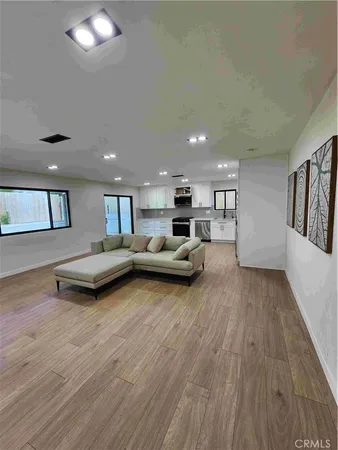 a living room with furniture and a wooden floor