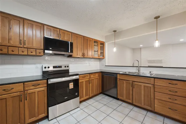 a kitchen with stainless steel appliances granite countertop a sink and stove top oven
