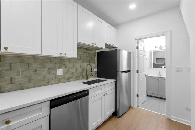 a kitchen with a sink a refrigerator and cabinets