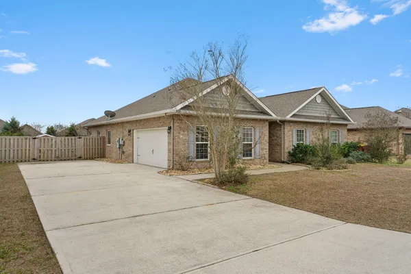 a front view of a house with a garden and yard