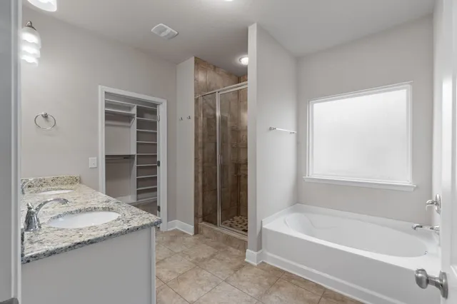 a bathroom with a granite countertop sink and a bathtub