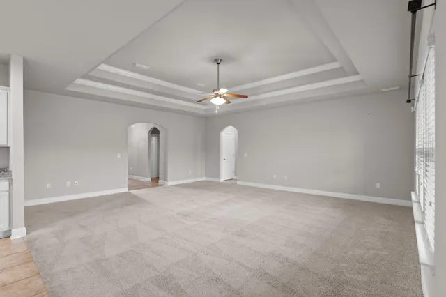 a view of a room with a ceiling fan and window