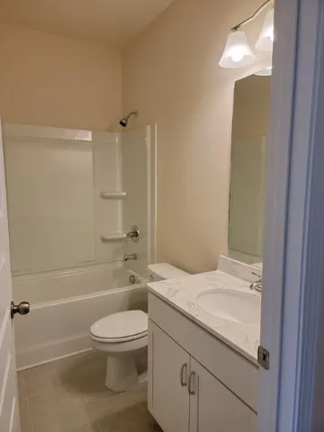 a bathroom with a granite countertop toilet a sink and bathtub