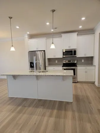 a kitchen with kitchen island a counter top space appliances and cabinets