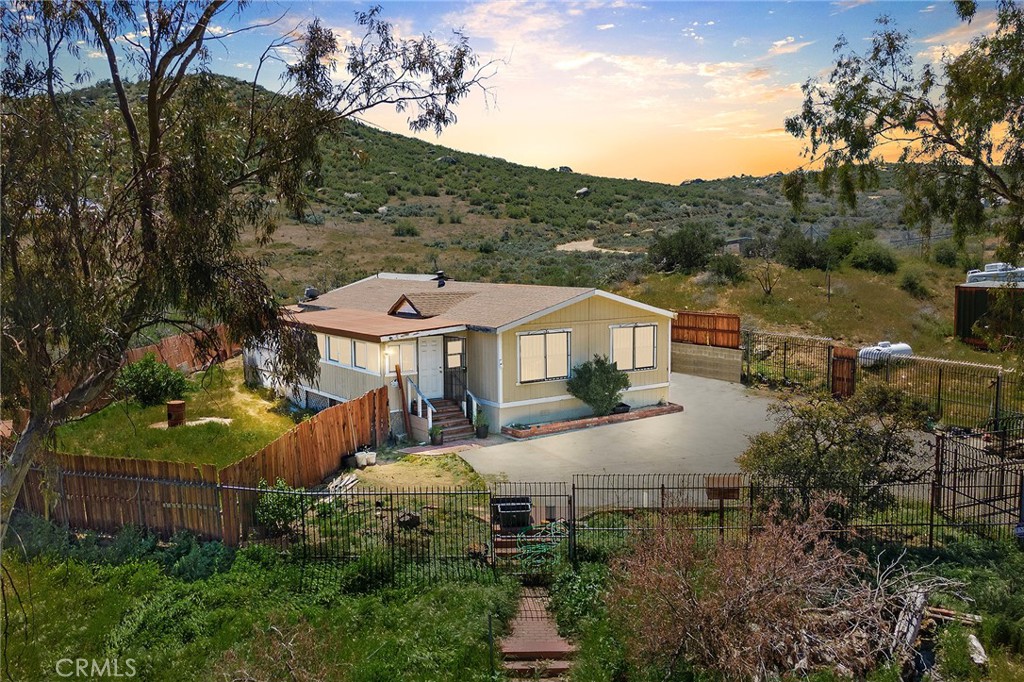 an aerial view of a house with yard and mountain view in back