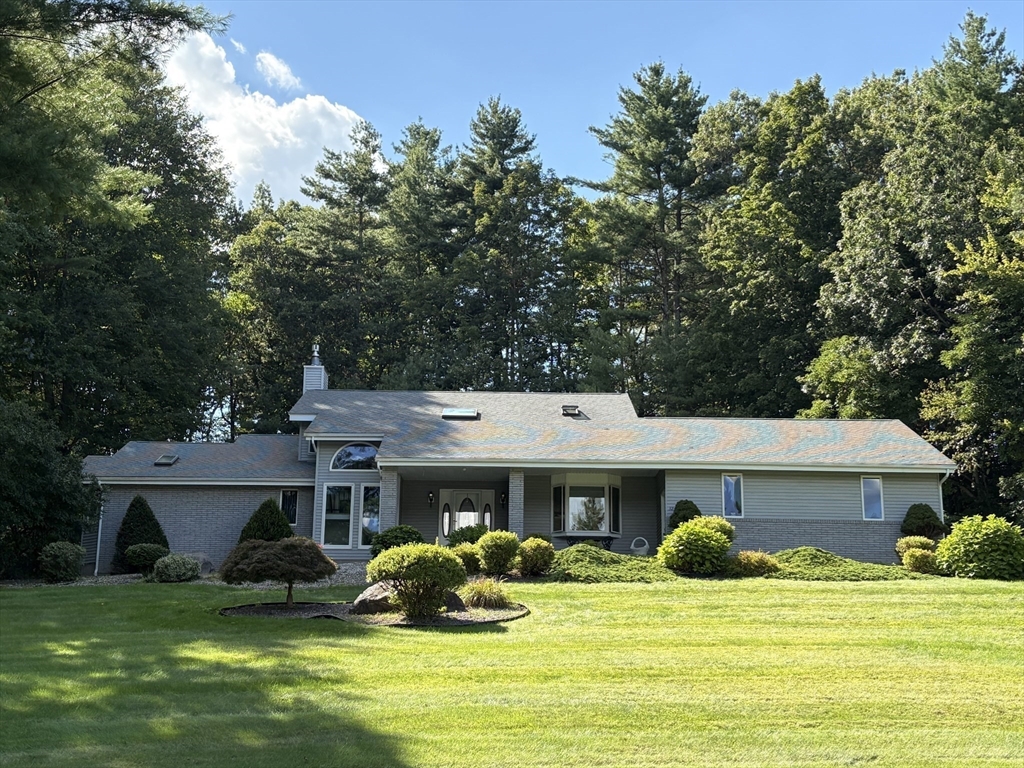 a view of a house with a patio and a yard