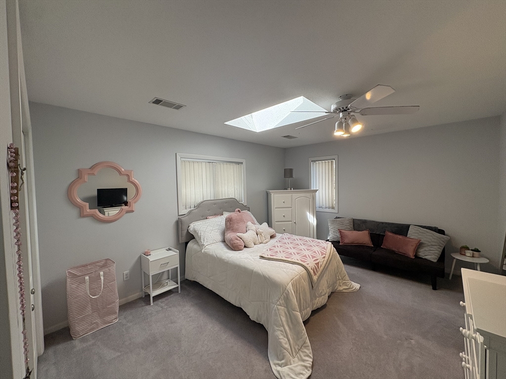 321 Westerly Circle Ludlow, MA 01056 - Photo 28 of 38 a bedroom with a bed a chandelier fan and a window