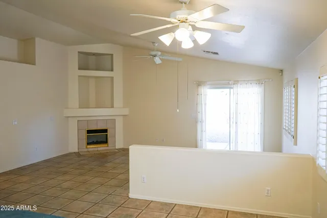 a view of an empty room with a fireplace and a window