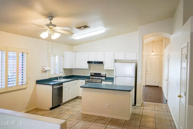 a kitchen with stainless steel appliances granite countertop a stove a sink and a refrigerator