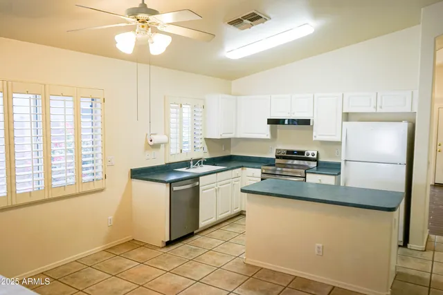 a kitchen with stainless steel appliances granite countertop a stove a sink and a refrigerator