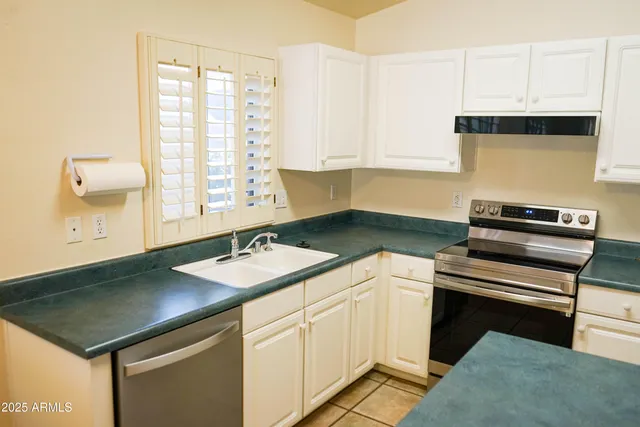 a kitchen with a sink cabinets and window