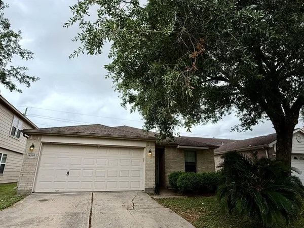 a small white house with a tree in front of it