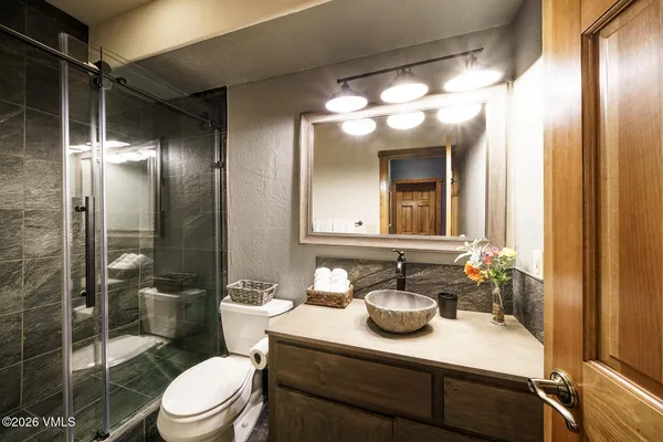 a bathroom with a sink a toilet and shower