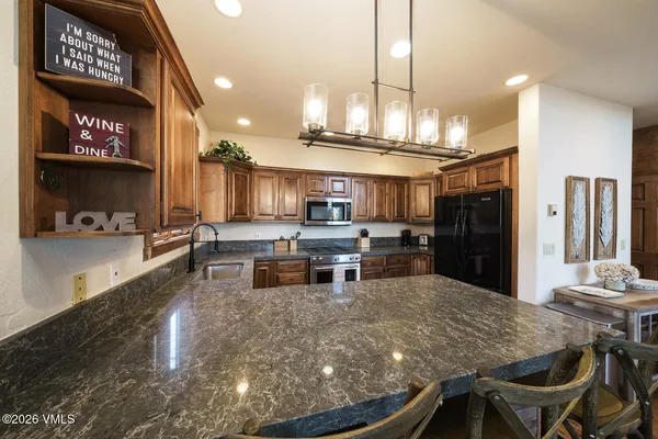 a kitchen with stainless steel appliances kitchen island granite countertop a sink and cabinets