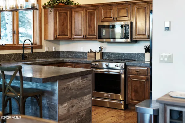 a kitchen with stainless steel appliances granite countertop a stove and a microwave