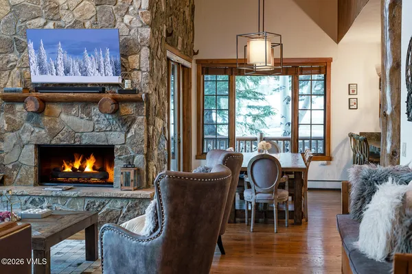 a dining room with furniture a fireplace and wooden floor