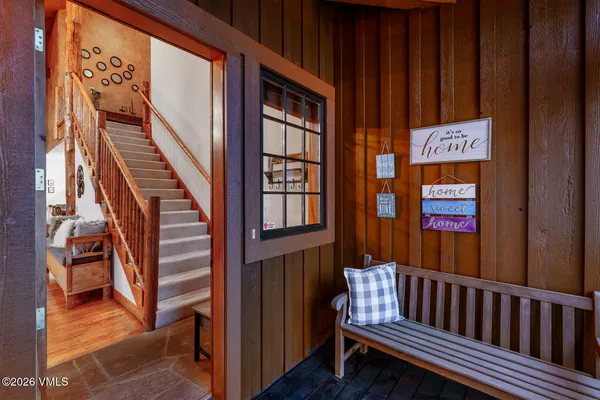 a view of staircase with lots of frames on wall and a window
