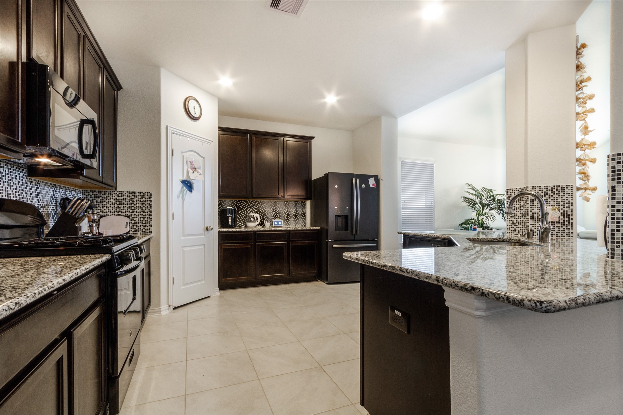 6305 Rotherham Street League City, TX 77573 - Photo 11 of 22 a kitchen with stainless steel appliances granite countertop a sink stove and refrigerator