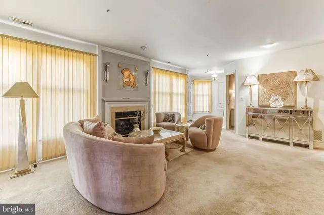 a living room with furniture a large window and a fireplace