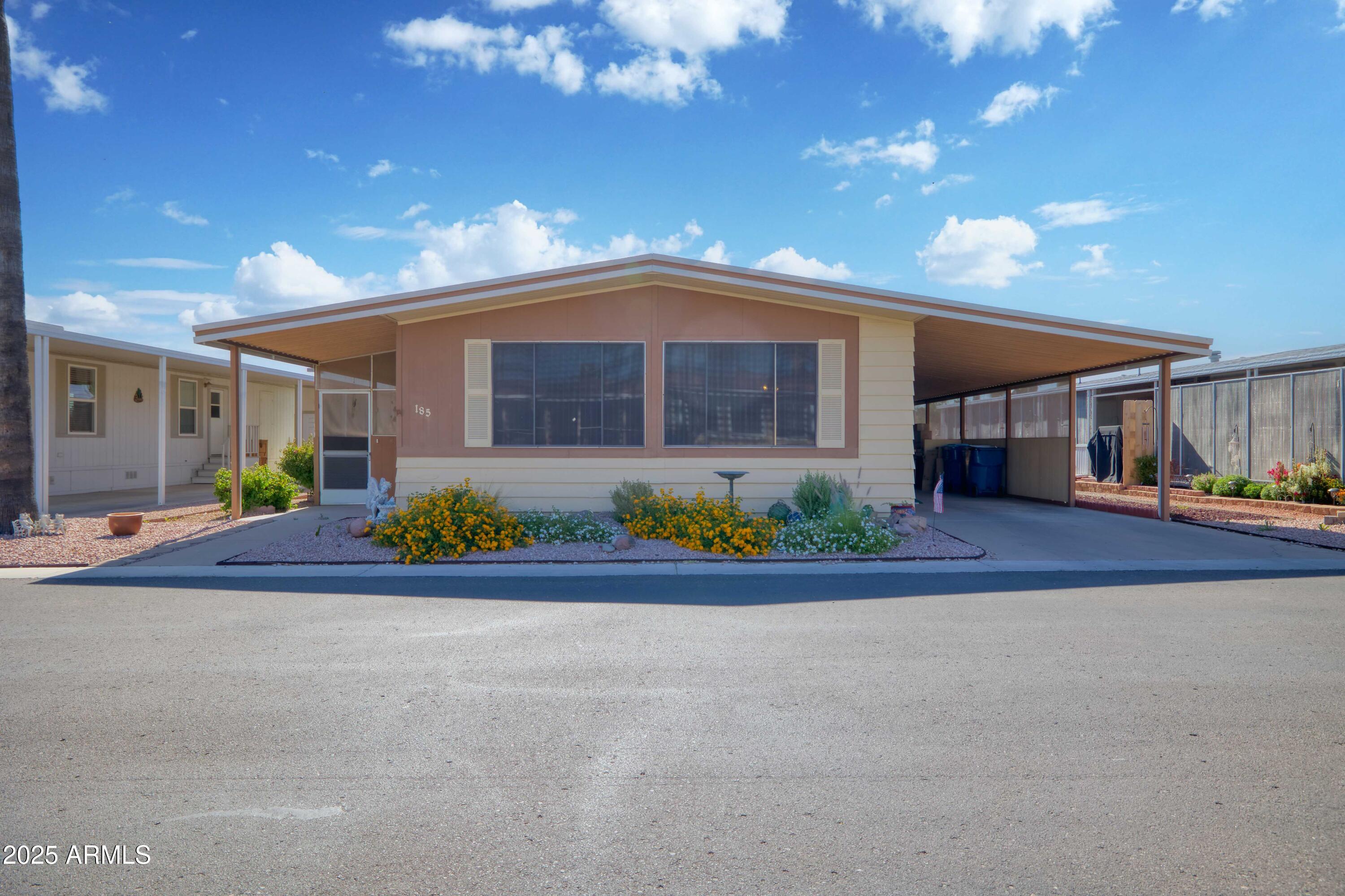 9302 East Broadway Road, Unit 185 Mesa, AZ 85208 - Photo 3 of 24 a front view of a house with garage and outdoor seating