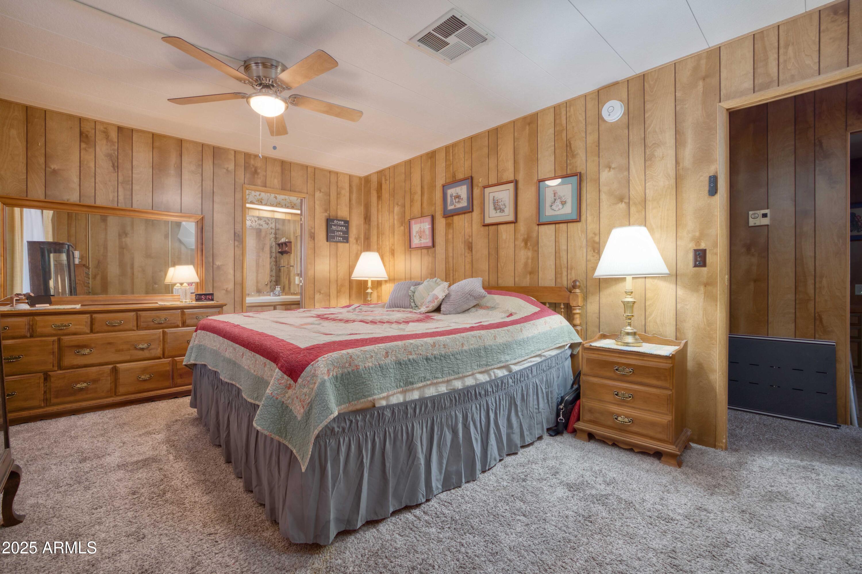 9302 East Broadway Road, Unit 185 Mesa, AZ 85208 - Photo 4 of 24 a bedroom with a bed and a chandelier